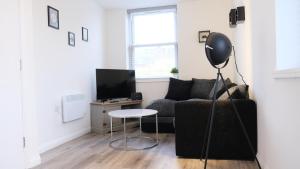 a living room with a couch and a table at Bedford Town Centre & Elegant Apartment inc PRIVATE Parking in Bedford