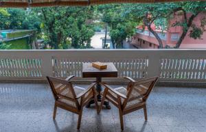 einen Tisch mit zwei Stühlen und ein Buch darauf in der Unterkunft Amrit Bhawan in Haridwar