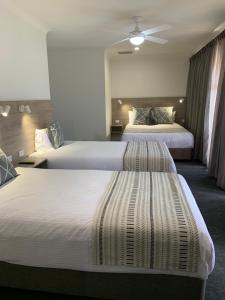 une chambre d'hôtel avec deux lits et un plafond dans l'établissement Hamilton Henry Parkes Motor Inn, à Parkes