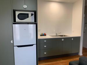 een keuken met een koelkast en een magnetron bij Hamilton Henry Parkes Motor Inn in Parkes