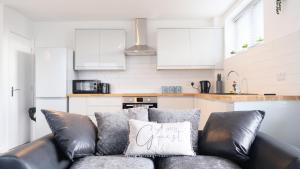 ein Sofa mit Kissen in der Küche in der Unterkunft Modern Contractors & Family Apartment - Central Location inc Private Parking in Bedford