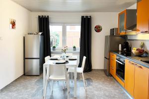 a kitchen with a table with chairs and a refrigerator at Cozy House in Zirndorf near Nürnberg in Zirndorf