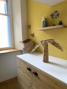 a kitchen with yellow walls and a wooden cabinet at L'équinoxe in Collioure