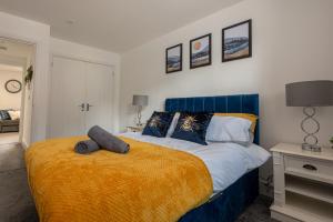 1 dormitorio con cama azul y manta amarilla en 5 MINS To CENTRAL - LONG STAY OFFER - FREE PARKING en Strood