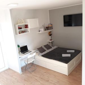 a bedroom with a bed with a desk and a laptop at Studio Apartman ''Nicole'' in Pula