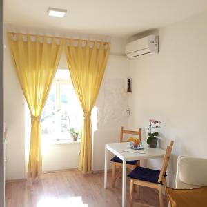 ein Wohnzimmer mit einem Tisch und einem Fenster in der Unterkunft Studio Apartman ''Nicole'' in Pula