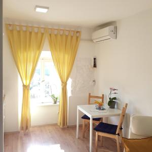 a living room with a table and a window at Studio Apartman ''Nicole'' in Pula