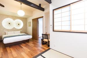 a bedroom with a bed and a desk and a window at 谷町君 星屋 神泉ノ宿 二条城 in Kyoto