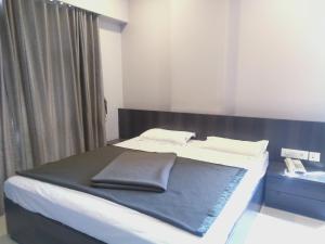 Postel nebo postele na pokoji v ubytování Sai Heera Residency Shirdi