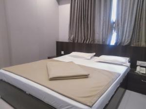 Postel nebo postele na pokoji v ubytování Sai Heera Residency Shirdi
