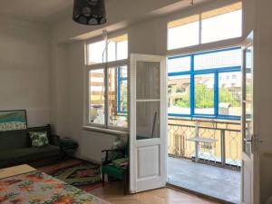 uma sala de estar com uma porta que abre para uma varanda em INOLA Sunny flat with balcony in central Tbilisi em Tbilisi