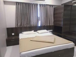 Postel nebo postele na pokoji v ubytování Sai Heera Residency Shirdi