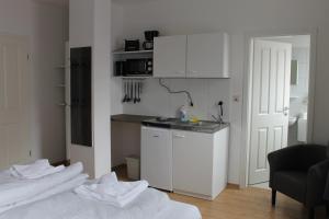 uma cozinha com armários brancos e toalhas brancas no chão em Boardinghouse Georgsheil em Südbrookmerland