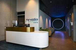 a lobby with a reception desk in a building at Nesuto Curtin Perth Hotel in Perth