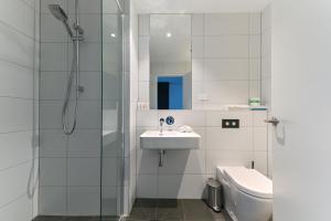 a bathroom with a shower and a sink and a toilet at Nesuto Curtin Perth Hotel in Perth +13 photos