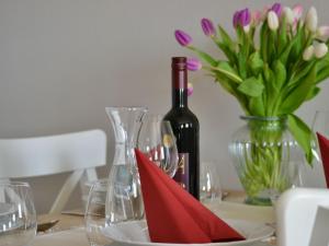 Ferienwohnung auf Gut Börtewitz في Leisnig: طاولة مع زجاجة من النبيذ و إناء من الزهور