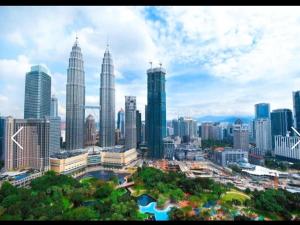 un perfil urbano con rascacielos altos en una ciudad en Soho Suites KLCC Kuala Lumpur, en Kuala Lumpur
