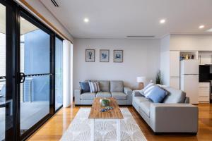 ein Wohnzimmer mit einem Sofa und einem Tisch in der Unterkunft Promenade Unit 4 in Geraldton