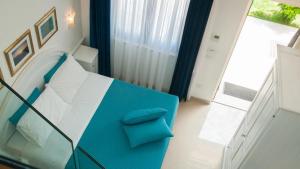 a blue and white bed in a room with a window at Agriturismo Il Casale di Monica in Rivotorto