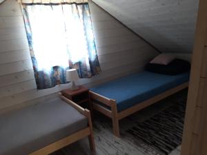 a small room with a bed and a window at W Krainie Okiennic in Trześcianka