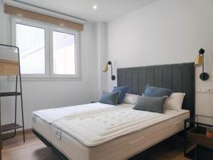 a large bed in a room with a window at Apartamentos Rey by Como en Casa in Santiago de Compostela