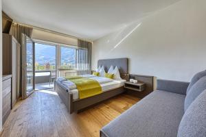 sypialnia z łóżkiem i dużym oknem w obiekcie Auhof w Meranie