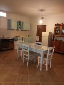 a kitchen with a table and chairs and a refrigerator at La Casa di Muro in Oriolo Romano