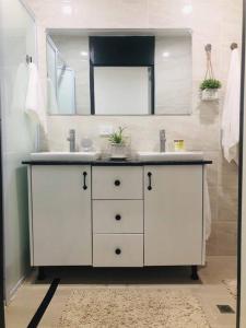 a bathroom with a white sink and a mirror at Suva City Accommodation in Suva