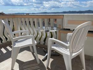 2 sillas y una mesa en el balcón en Rooms and Apartments Ana, en Zadar