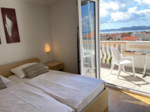 a bedroom with a bed and a balcony with a table and chairs at Rooms and Apartments Ana in Zadar