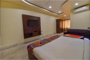 a bedroom with a large bed and a tv at FabHotel Red Rose in Amingaon