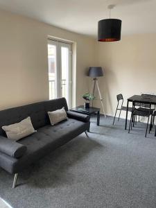 a living room with a couch and a table at Lovely 1 bedroom studio apartment - Merthyr Tydfil in Merthyr Tydfil