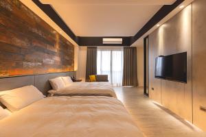 ein Hotelzimmer mit 2 Betten und einem Flachbild-TV in der Unterkunft Sugar Island Inn in Magong