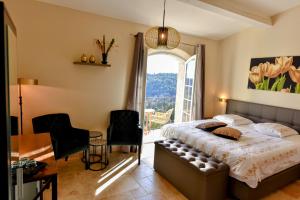 a bedroom with a bed and a large window at Chambre d'hôtes Cottes in Callian