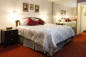 1 dormitorio con 1 cama grande con almohadas rojas en Niagara Falls Motor Lodge, en Niagara Falls