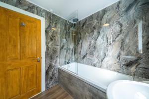 bagno con parete in pietra di Lagnaha Cottage a Kentallen Altre 34 foto