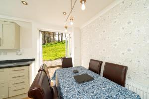 una sala da pranzo con tavolo, sedie e una finestra di Lagnaha Cottage a Kentallen