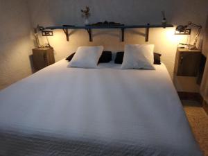 a large white bed with two pillows on it at Alojamiento Gran Descanso in Villena