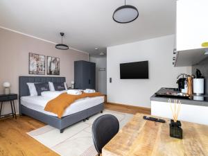 a bedroom with a king sized bed and a kitchen at limehome Villach Gerbergasse in Villach