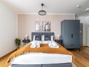 een slaapkamer met een groot bed met 2 nachtkastjes bij limehome Villach Gerbergasse in Villach