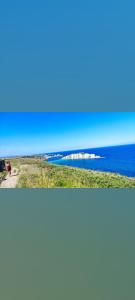 two pictures of the ocean and a person walking on a beach at Coqueto Dúplex con dos terrazas y piscina cerca de la playa de la Virgen del Mar in Santander