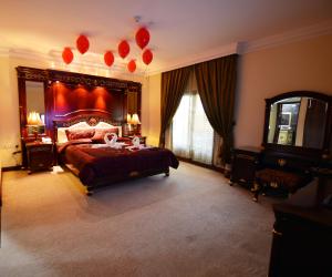 una camera da letto con un grande letto con palloncini rossi di The Convention Center & Royal Suites Hotel a Kuwait