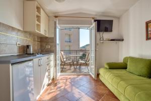 a kitchen and a living room with a couch at Apartmani Olga in Petrovac na Moru