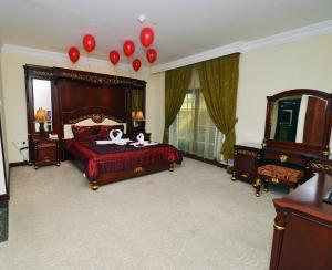 Un dormitorio con una cama con globos rojos. en The Convention Center & Royal Suites Hotel en Kuwait