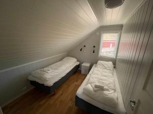 a room with two beds and a window in it at Lofoten Havfiske in Leknes