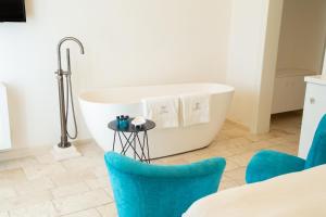 a bathroom with a bath tub and blue chairs at Dimora Graziana 1909 in Locorotondo