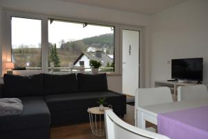 a living room with a couch and a large window at Fewo Ausspann in Stryck