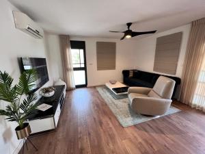 uma sala de estar com um sofá e uma cadeira em Hadar Rest & Relax em Kefar H̱ittim