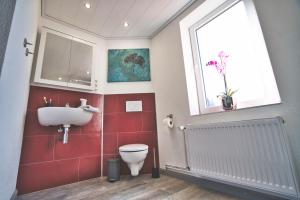 a bathroom with a toilet and a sink and a window at Ferienhaus Eulenspiegel in Clausthal-Zellerfeld +24 photos