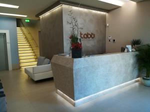 a lobby with a reception desk and a couch at Tabù Hotel in Porto Cesareo